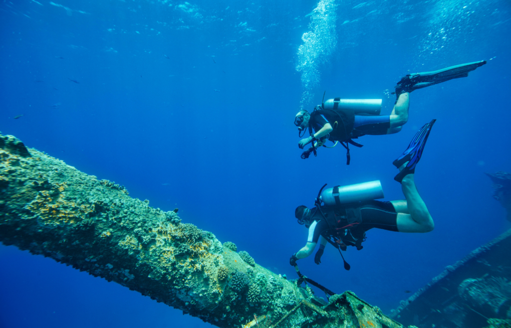 scuba divers exploring a wreck