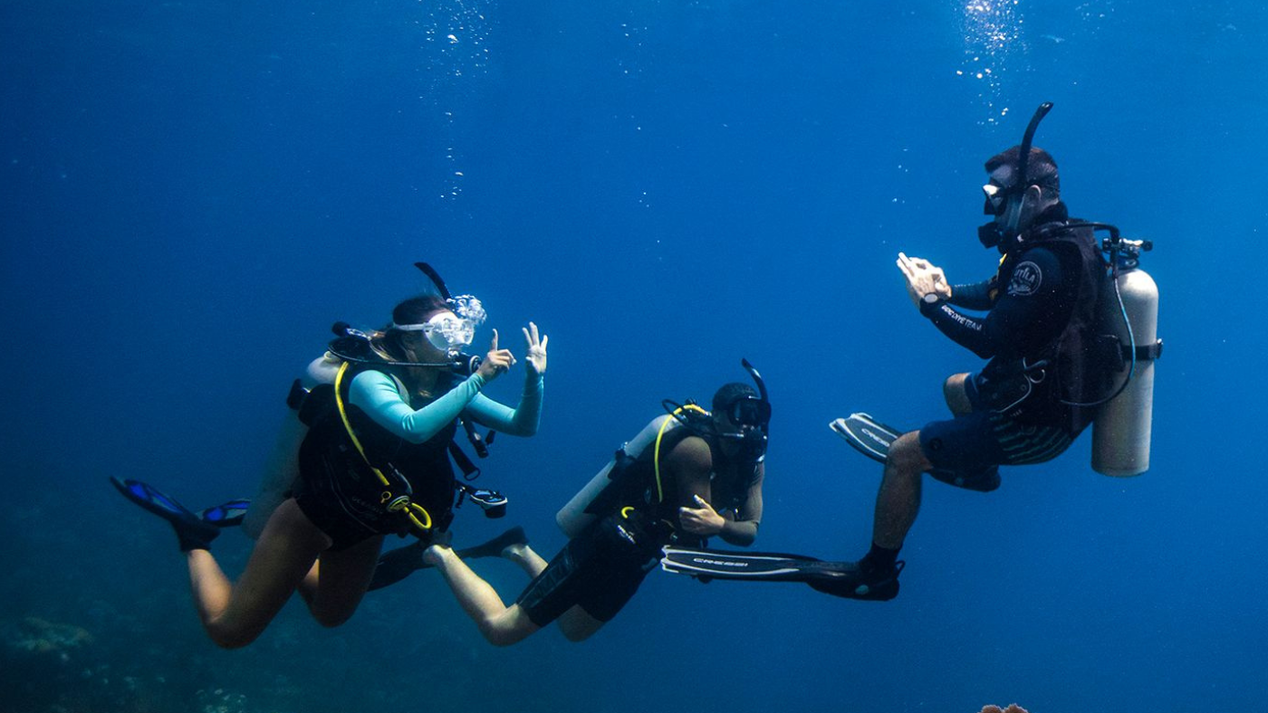 Three Scuba Diver friends who have the same hobby of going on scuba adventures together.